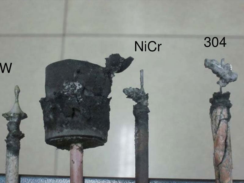 A visual comparison of anode materials after use, displaying the condition of Tungsten (W), Nichrome (NiCr), and 304 stainless steel, each exhibiting significant corrosion and degradation. A visual comparison of anode materials after use, displaying the condition of Tungsten (W), Nichrome (NiCr), and 304 stainless steel, each exhibiting significant corrosion and degradation.